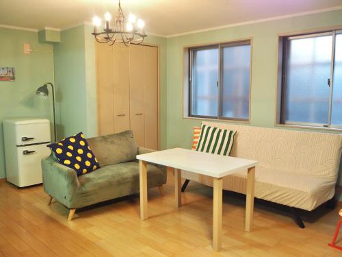 a living room with a couch and a table and a chair at Grand Opening Sale!!! 最大5人まで-関西空港近く-JR日根野駅前-貸切一軒家 Entire House Near Kansai Airport-Max 5 people-The Palm Guest House in Izumi-Sano