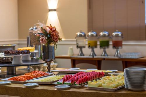 a buffet with different types of food on a table at Braston Augusta Hotel by Castelo Itaipava in Sao Paulo