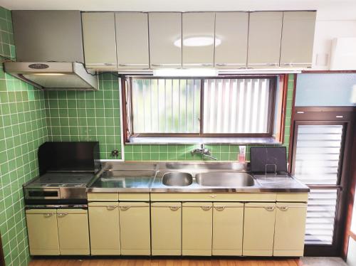 御殿場市にある駅近2分 昭和の家のシンクとコンロのあるキッチン