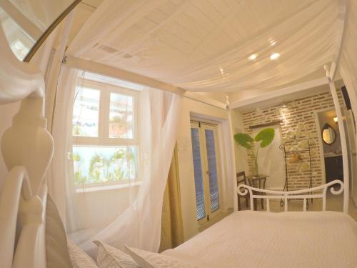 a bedroom with a white canopy bed with a window at Casa Heredia Boutique in Cartagena de Indias