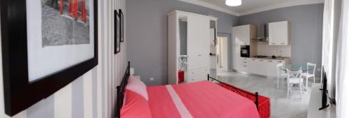 サンターガタ・デ・ゴーティにあるGiualduomo B&Bのベッドルーム1室(赤いベッド1台付)、キッチンが備わります。