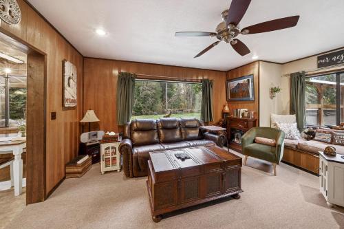 Sasquatch Sanctuary | Hot tub في باكوود: غرفة معيشة مع أريكة ومروحة سقف