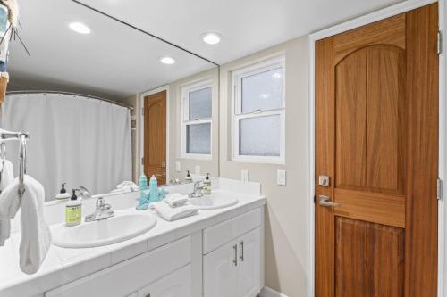 ein Badezimmer mit zwei Waschbecken und einem Spiegel in der Unterkunft Hawaiian Style Beachfront on Beach Road in Capistrano Beach