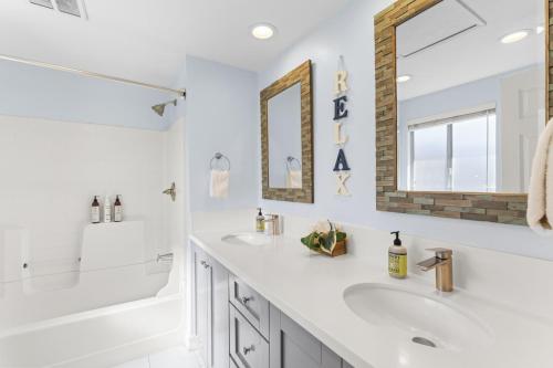 ein weißes Badezimmer mit zwei Waschbecken und einem Spiegel in der Unterkunft Hideaway B Walk to the beach Downtown AC in San Clemente