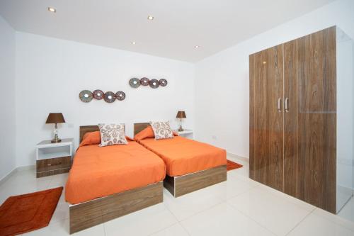 1 dormitorio con 1 cama y armario de madera en InStyle Aparthotel, en San Julián