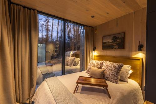 a bedroom with a bed and a large window at The Illusion Hideaway in New Plymouth