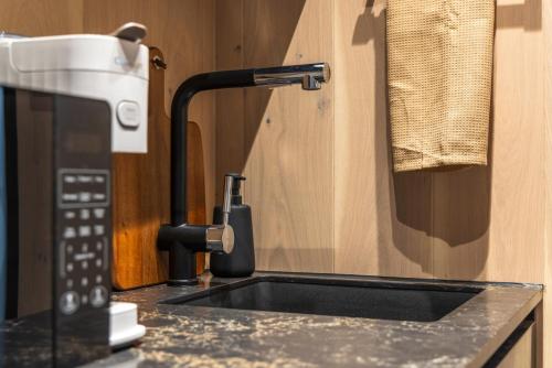 a kitchen counter with a sink and a microwave at The Illusion Hideaway in New Plymouth