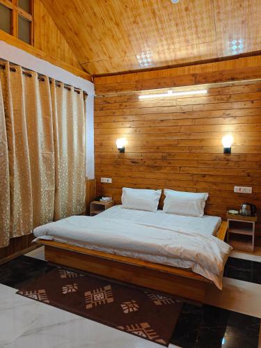 a bedroom with a bed with a wooden wall at Mistymountaincottage in Shimla