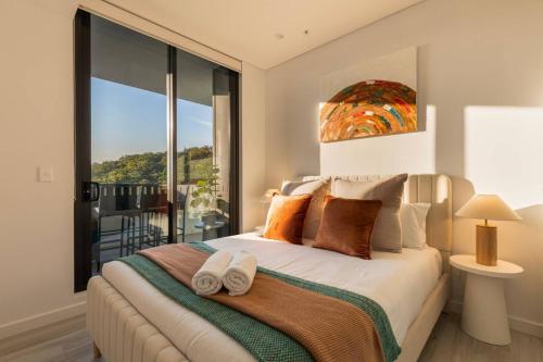 Waterfront Apartment in the Heart of Gosford في جوسفورد: غرفة نوم بها سرير مع نافذة كبيرة