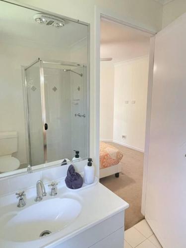 a white bathroom with a sink and a mirror at Riverview Modern Haven in Riverview