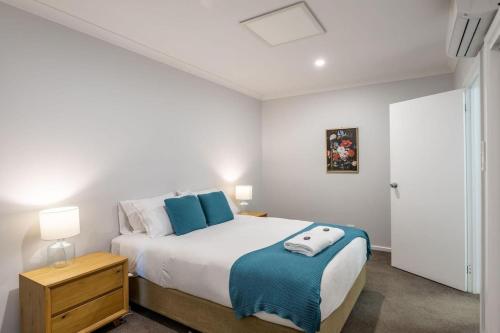a bedroom with a large bed with blue pillows at Central Chic- Beautifully appointed townhouse in Myrtleford