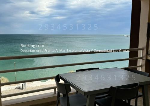 Un balcón con mesa y sillas y el mar. en VISTA AL MAR Departamento Frente Al Mar Excelente Vista Y Comodidad Las Grutas, en Las Grutas