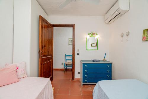 ein Schlafzimmer mit 2 Betten und einer blauen Kommode in der Unterkunft VILLA PITRIZZINA 8, Emma Villas in Liscia di Vacca