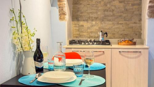 a kitchen with a table with plates and wine glasses at La Casa Gialla by Ca-Sa Check in Chioggia