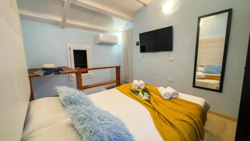 a bedroom with a bed with a yellow blanket and a mirror at La Casa Gialla by Ca-Sa Check in Chioggia