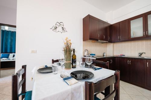 a kitchen with a table with a white table cloth at ERAL Apart-Hotel & Penthouse in Sarandë