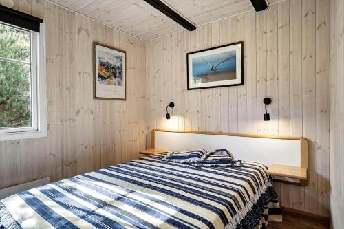 a bedroom with a bed with a striped blanket on it at 1344-Vestervig-Hedevej-43 in Vestervig