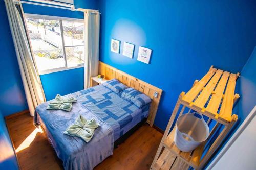 ein blaues Schlafzimmer mit einem Bett und einem Fenster in der Unterkunft Confortável AP próximo ao parque e praias in Penha