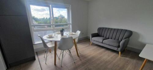 a living room with a table and a chair and a couch at New Refurbed 4BDR on Dock Road Near City Centre in Limerick