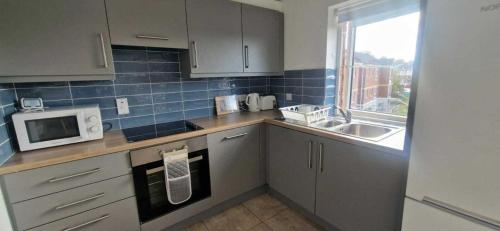 a kitchen with a sink and a microwave at New Refurbed 4BDR on Dock Road Near City Centre in Limerick