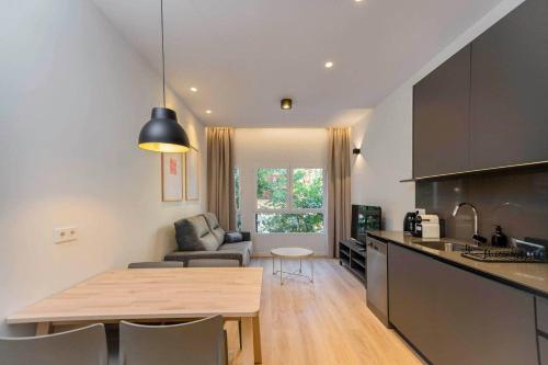 a kitchen and living room with a table and a couch at Stancia Benimaclet - Studio 9 in Valencia