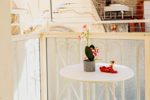 un tavolo con una pianta in vaso accanto a una finestra di Jordan Apartment a Napoli