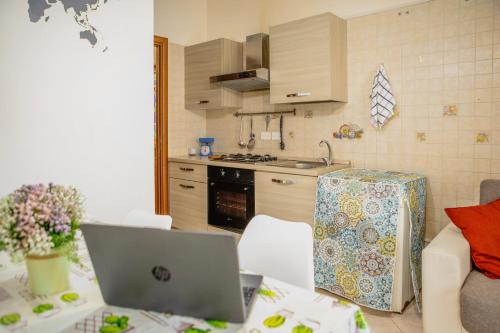 una cucina con un tavolo con un computer portatile sopra di Jordan Apartment a Napoli