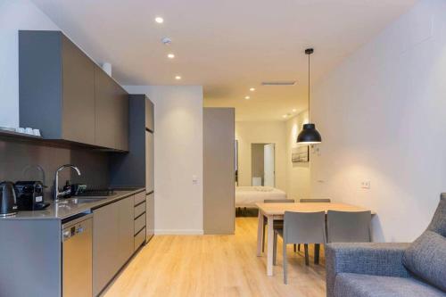 a kitchen and living room with a table and a couch at Stancia Benimaclet - Studio 1 in Valencia
