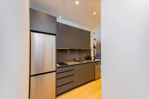 a kitchen with stainless steel appliances and a white wall at Stancia Benimaclet - Studio 11 in Valencia