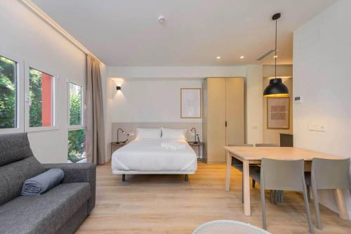 a bedroom with a bed and a table and a couch at Stancia Benimaclet - Studio 11 in Valencia