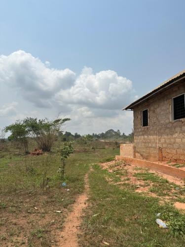 BamgboseにあるHiro Hotelの畑の建物の隣の未舗装道路