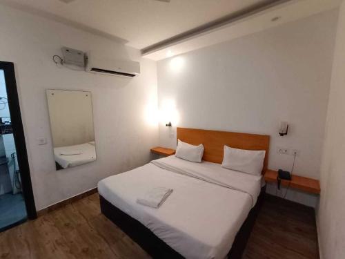 a bedroom with a large white bed and a mirror at Hotel O Sector 18 Dhaliawas Crossway Rewari Formerly Ignis in Rewāri