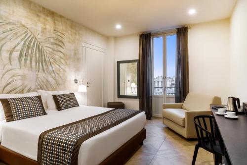 a hotel room with a bed and a desk and a chair at Best Western Plus Royal Superga Hotel in Cuneo