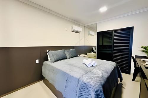 um quarto com uma cama com duas toalhas em Studio Ônix - A poucos passos da Ufu. em Uberlândia