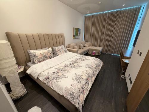 Un dormitorio con una cama grande y un sofá. en Sea View Studio Perfect for Couples In Harbour Row, en Manama