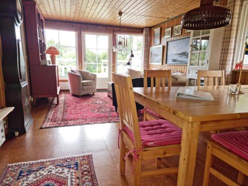 Cottage with Natural Plot and Sauna on Mjörn SE09134 في Dyvik: غرفة طعام وغرفة معيشة مع طاولة وكراسي