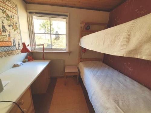 Cottage with Natural Plot and Sauna on Mjörn SE09134 في Dyvik: غرفة صغيرة مع سرير بطابقين ونافذة