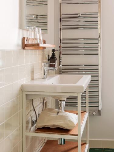 a bathroom with a white sink and a mirror at Alfred Hotels Paris Gare du Nord- Hôtel Rénové in Paris