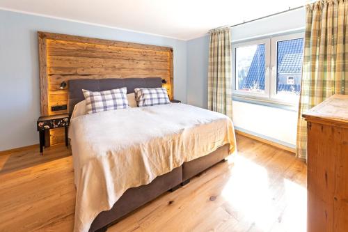a bedroom with a large bed with a wooden headboard at Eden Escapes in Olsberg