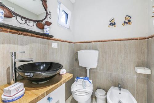 La Casa Fra gli Ulivi luxury apartments with pool near Cinque Terre and Tuscany في مونتيمارتشيلو: حمام مع حوض غسيل أسود ومرحاض