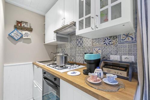 La Casa Fra gli Ulivi luxury apartments with pool near Cinque Terre and Tuscany في مونتيمارتشيلو: مطبخ صغير مع موقد وميكروويف