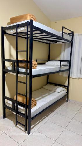 a black bunk bed with the bottom bunkessionsktop at Hostel Ôxe in Paraty