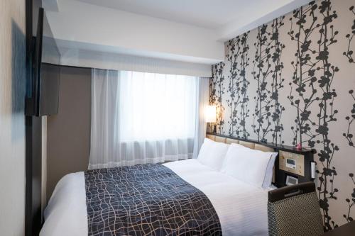 a hotel room with a bed and a window at APA Hotel Asakusa Tawaramachi Ekimae in Tokyo