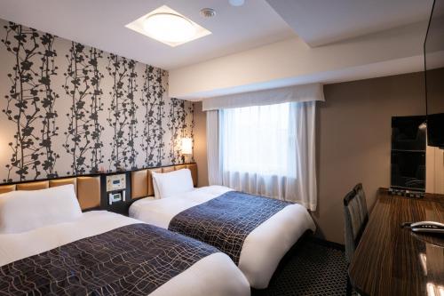 a hotel room with two beds and a table at APA Hotel Asakusa Tawaramachi Ekimae in Tokyo