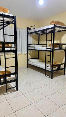 two bunk beds in a room with a tile floor at Hostel Ôxe in Paraty