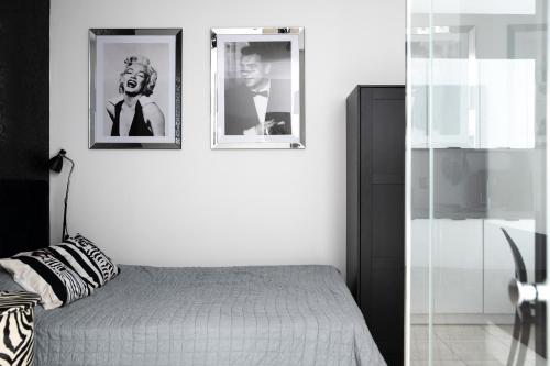 a bedroom with two pictures on the wall at Nowoczesny apartament GLAMOUR Łódź z prysznicem pośrodku in Łódź