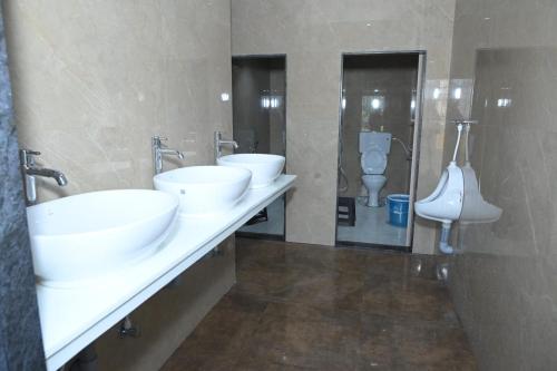 een badkamer met 2 wastafels en een toilet bij Umaa Sleeping Beds Dormitory in Pārvatīpuram