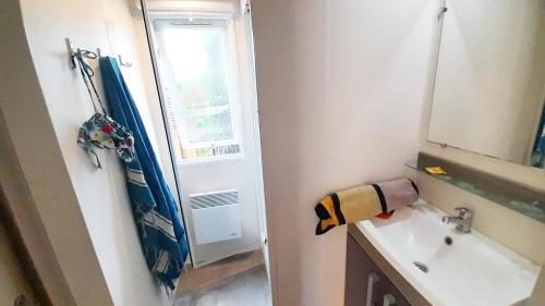 a small bathroom with a sink and a window at Camping Tikayan La Célestine - Maeva in Beynes