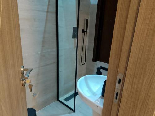 a bathroom with a shower and a white sink at Pazo by TLL in Ilorin
