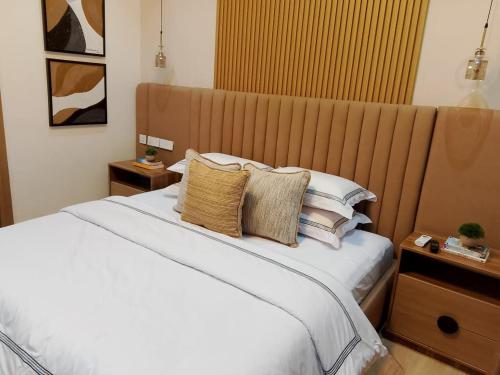 a bedroom with a large white bed with pillows at Pazo by TLL in Ilorin